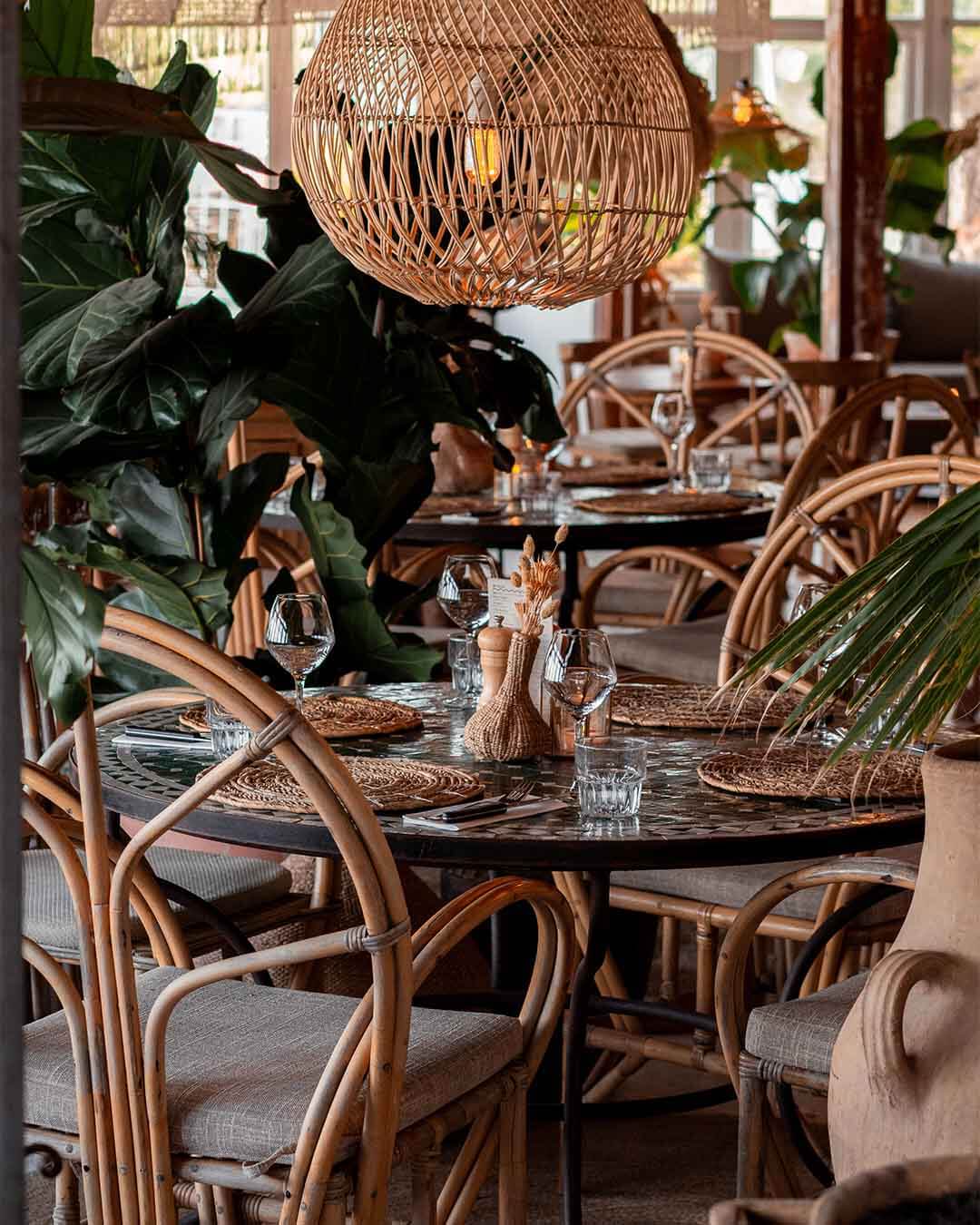 Ingedekte tafel met grote rotan stoelen bij Kayuca