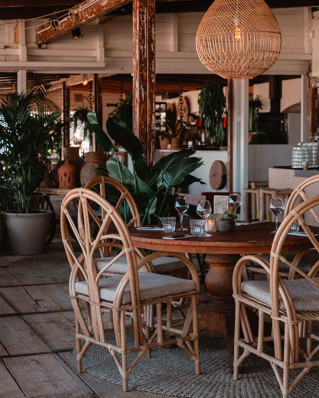 Ingedekte tafel met grote rotan stoelen bij Kayuca