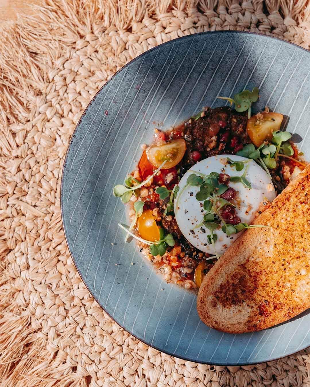 Bovenaanzicht van burrata met tomaten en crouton