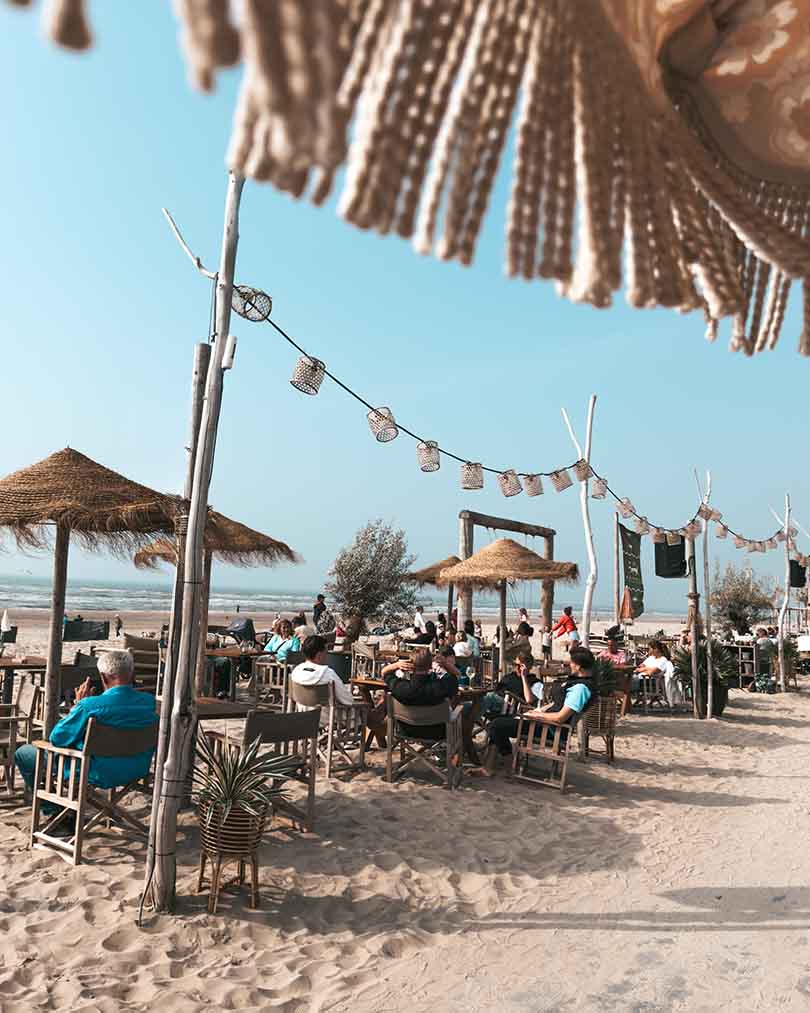 Vol terras tijdens lunch in het zand onder de parasol